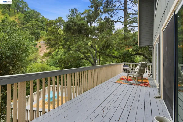 a balcony with wooden floor and outdoor seating