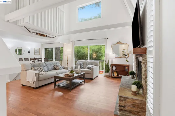 a living room with furniture a fireplace and a large window