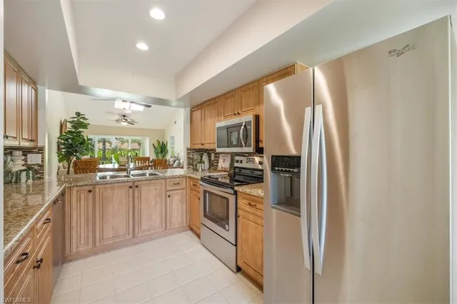 a kitchen with stainless steel appliances granite countertop a refrigerator and a stove top oven