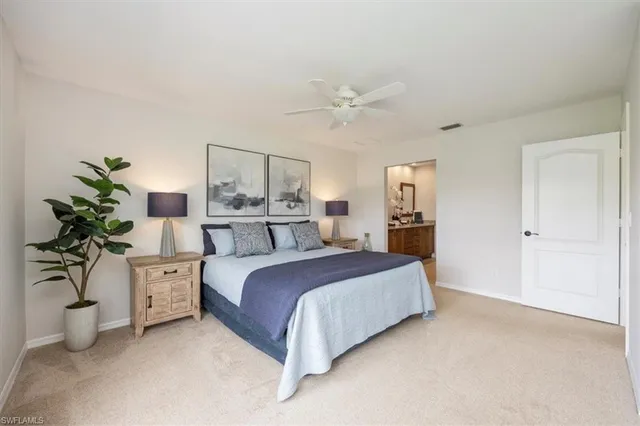 a bedroom with a large bed and a potted plant