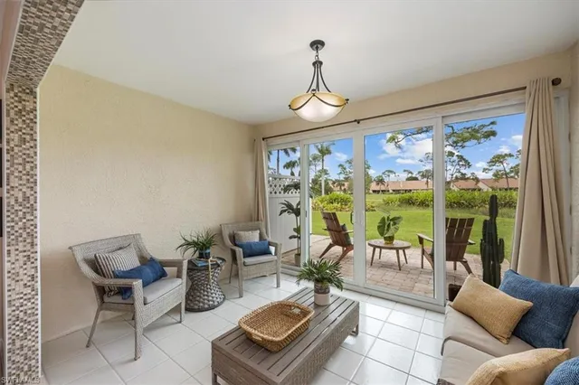 a living room with furniture and floor to ceiling windows
