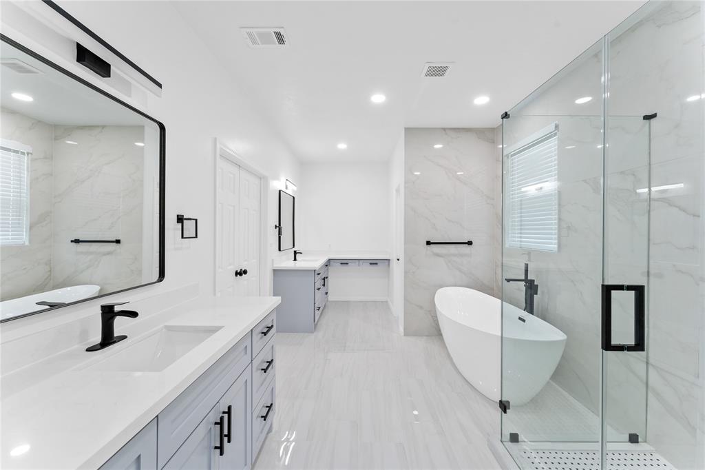 a bathroom with a double vanity sink a mirror and a bathtub