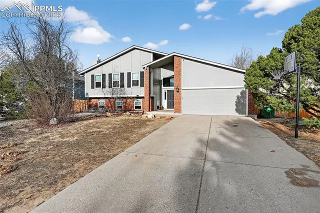 a white house that has tree in front of it