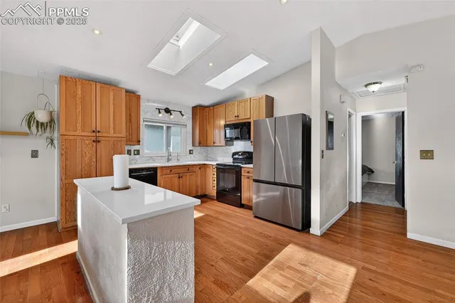 a kitchen with stainless steel appliances a refrigerator and a stove top oven