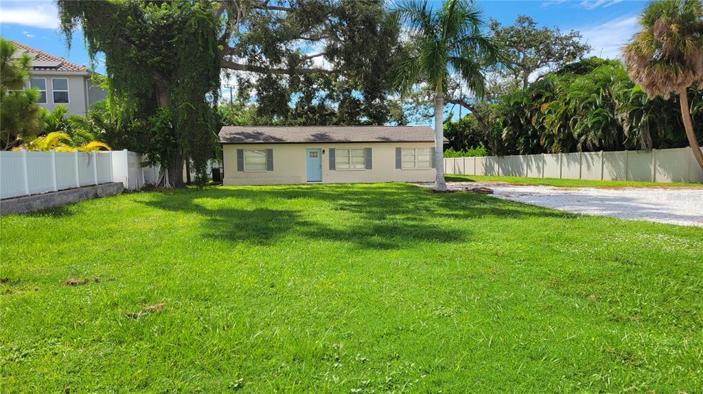 a view of a house with a backyard and a tree