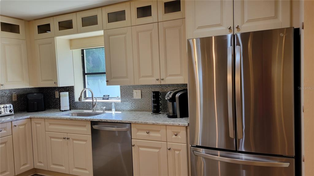 3932 Sunshine Avenue Sarasota, FL 34231 - Photo 6 of 17 a kitchen with stainless steel appliances granite countertop a refrigerator and a stove top oven