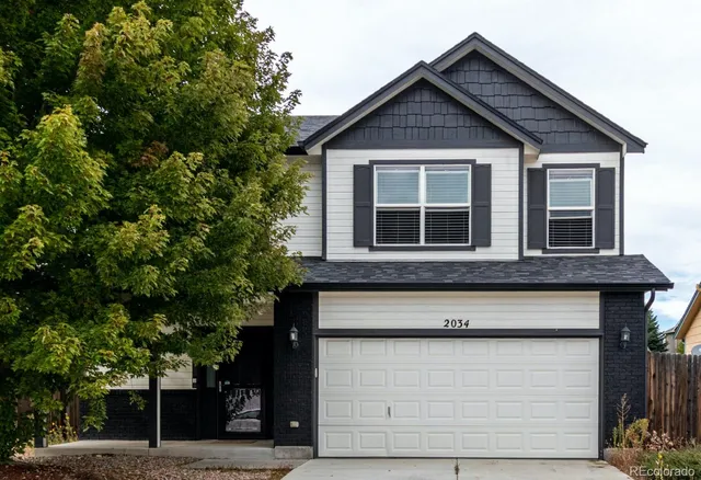 a front view of a house with a tree