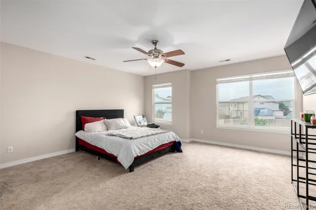 a spacious bedroom with a bed and a large window with view of bedroom