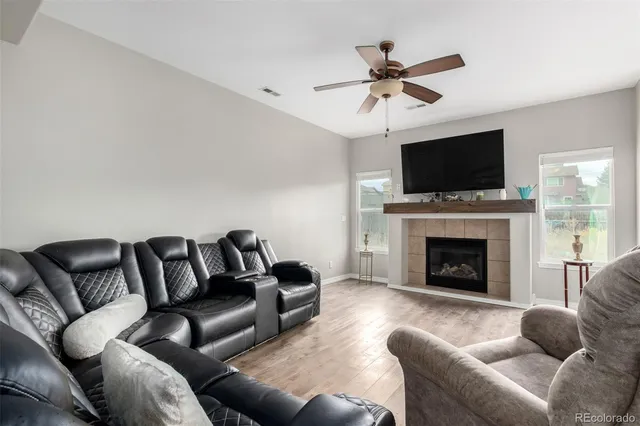 a living room with furniture a fireplace and a flat screen tv