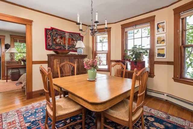 a dining room with furniture a chandelier and wooden floor