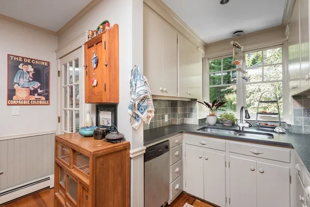 a kitchen with a sink cabinets appliances and a large window