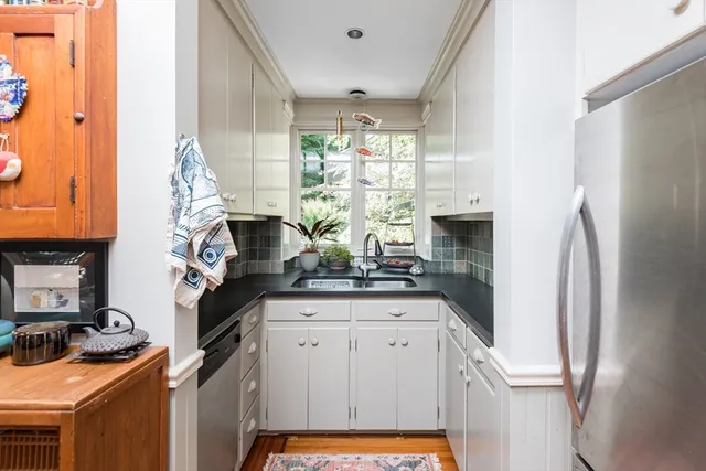 a kitchen with stainless steel appliances granite countertop a stove a refrigerator and a white cabinets