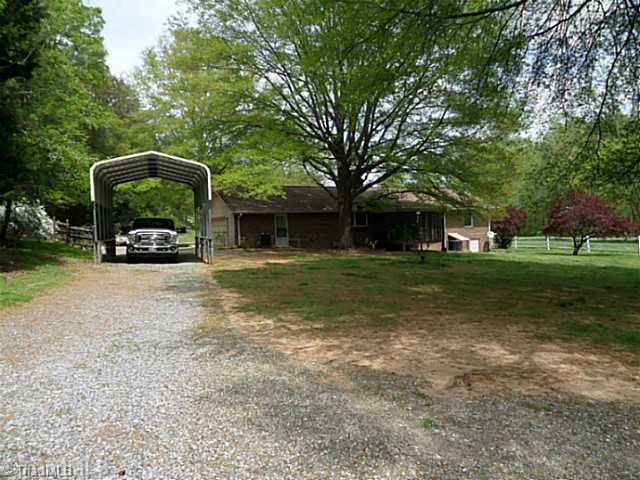 1258 Leake Memorial Church Road Germanton, NC 27019 - Photo 14 of 16 Exterior Front. Side view of the house shows the 2 car attached garage and the walk through door to the right. The seller added a high profile carport that can house an RV.