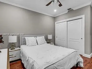 a bed room with a bed and a ceiling fan