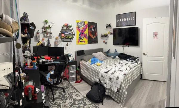 a bedroom with a bed and a flat screen tv