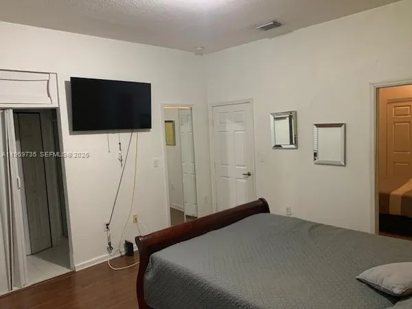a bedroom with a bed and a flat screen tv