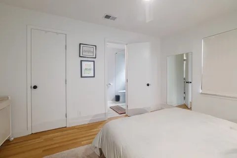 a bedroom with a bed and painting on the wall