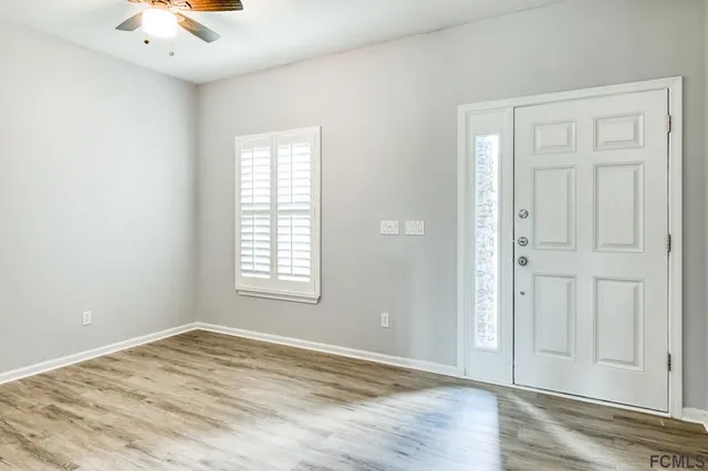 an empty room with window and a ceiling fan