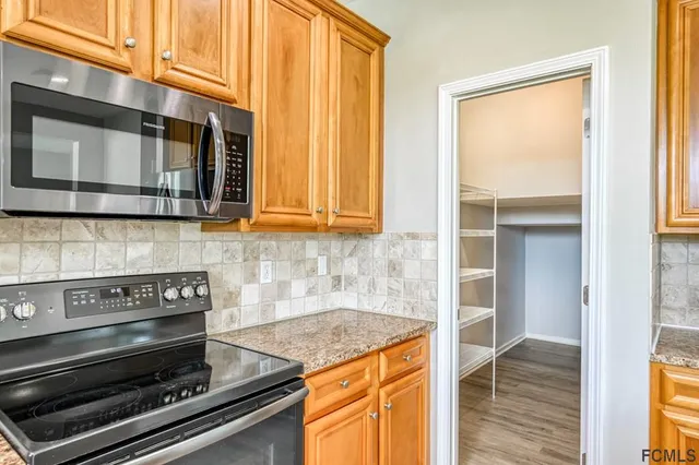 a kitchen with stainless steel appliances granite countertop a stove and a microwave