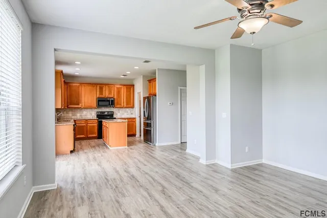 a large kitchen with a wooden floor and stainless steel appliances