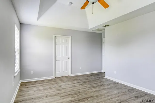 a view of an empty room with wooden floor