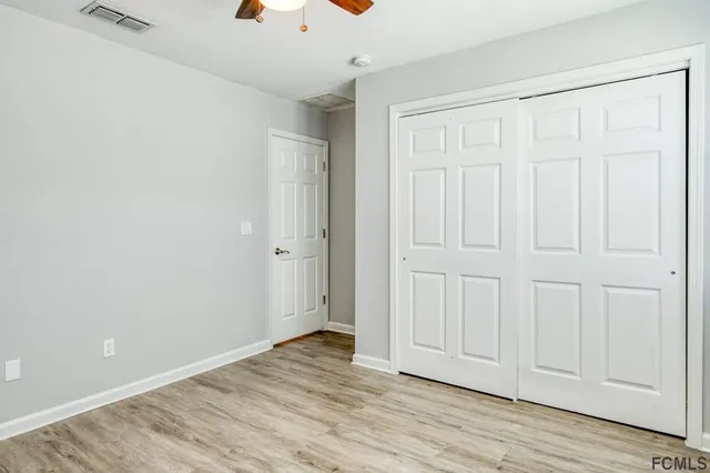an empty room with wooden floor and entryway