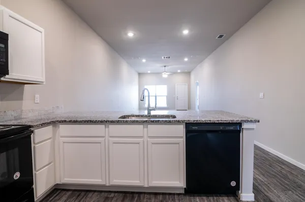 a kitchen with granite countertop a sink and cabinets