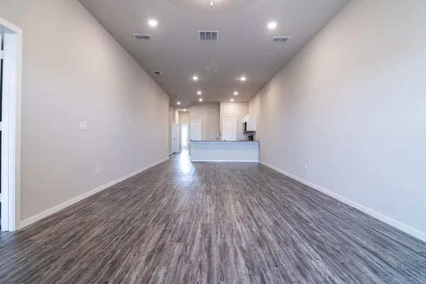a view of a room with wooden floor and window