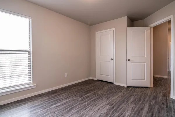 an empty room with wooden floor and window
