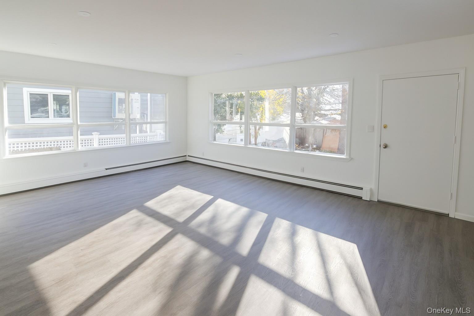 540 East State Street Long Beach, NY 11561 - Photo 5 of 12 Spare room with baseboard heating and wood finished floors