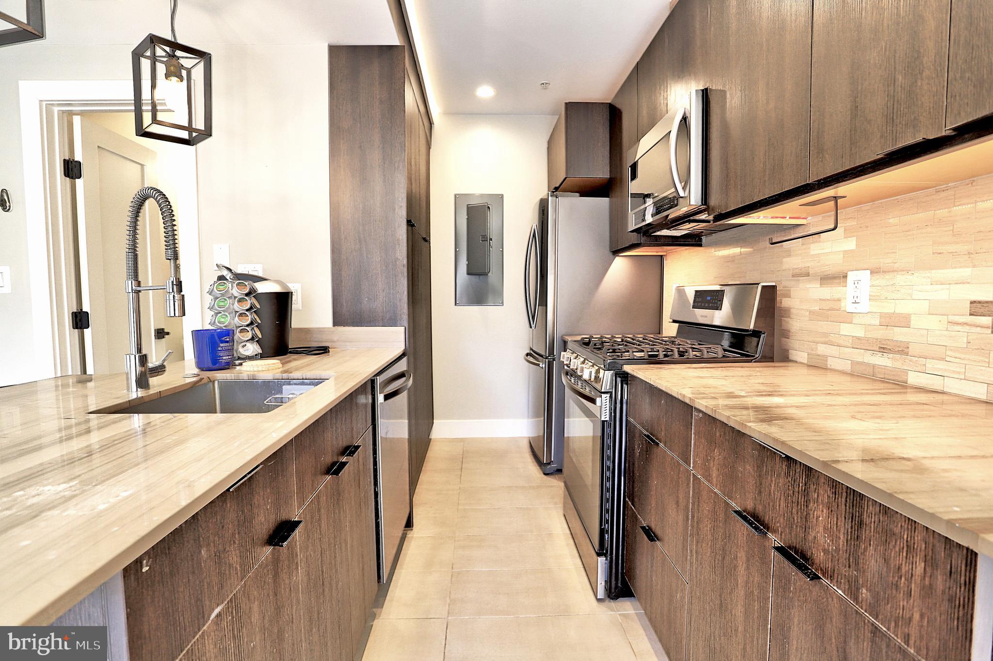 1723 Wisconsin Avenue Northwest, Unit B Washington, DC 20007 - Photo 4 of 20 a large kitchen with stainless steel appliances granite countertop a sink counter space and a view of living room