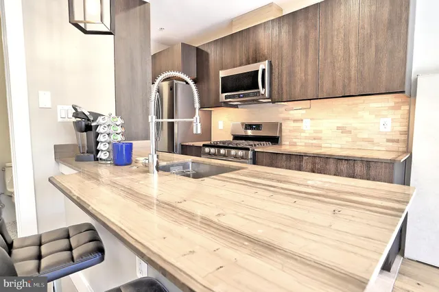 a kitchen with granite countertop a stove and a wooden floor