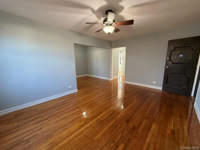 a view of an empty room with wooden floor