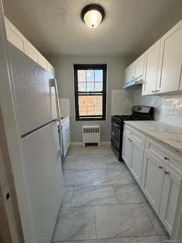 a kitchen with a refrigerator and a stove top oven