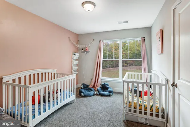a view of a bedroom with wooden floor & windows