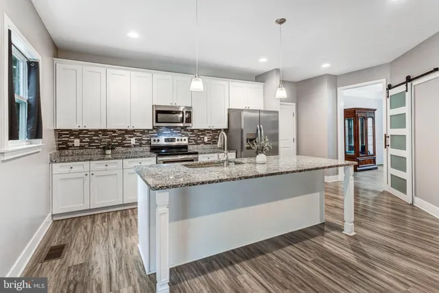 a kitchen with stainless steel appliances granite countertop a stove a sink and a refrigerator
