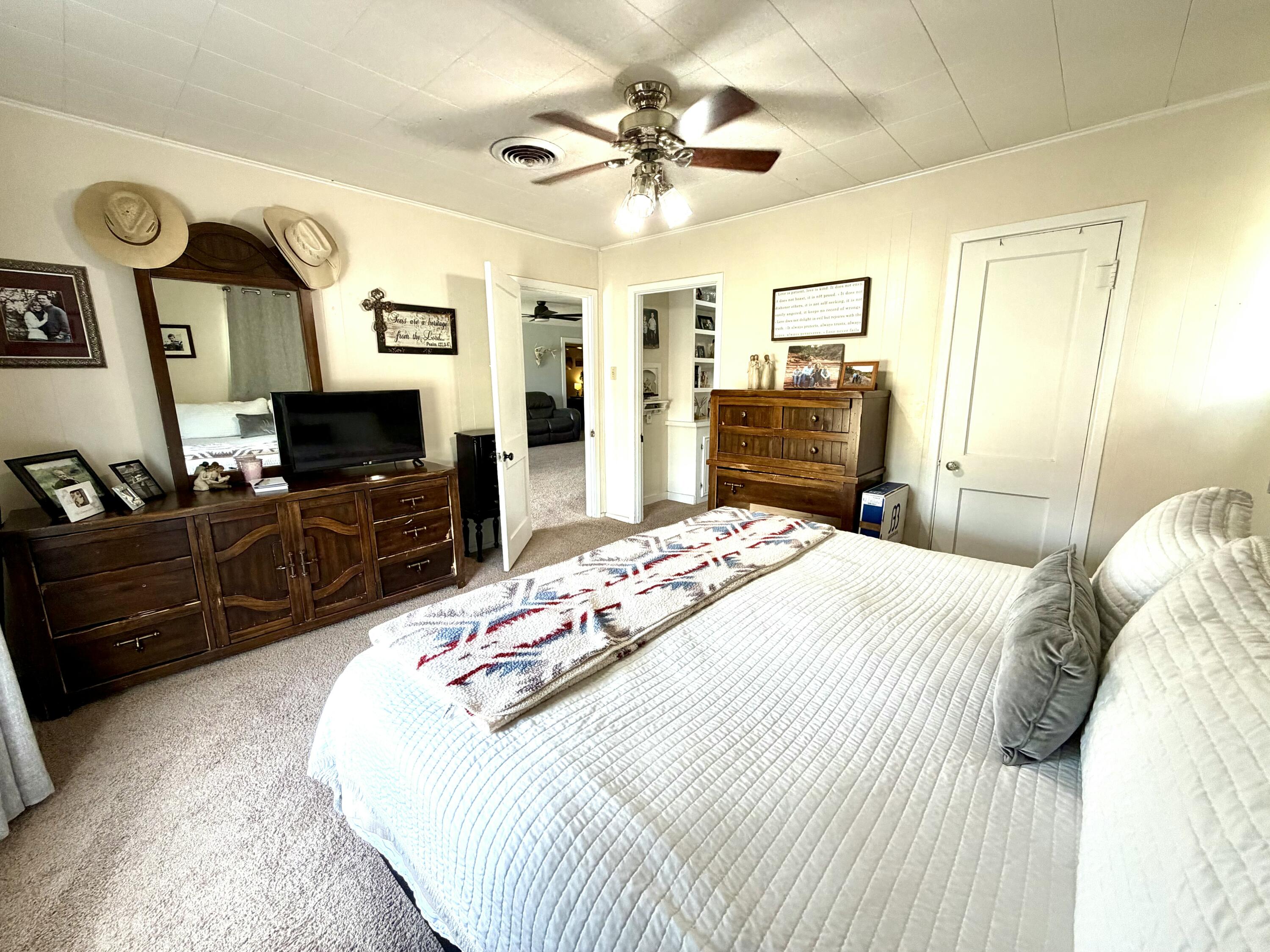207 2nd Street Quitaque, TX 79255 - Photo 5 of 9 a bedroom with a bed a dresser and flat screen tv