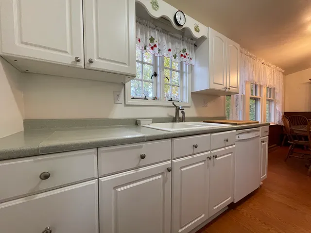 a kitchen with granite countertop white cabinets and white appliances