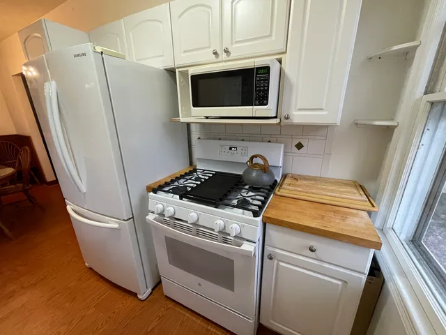 a kitchen with stainless steel appliances and white cabinets