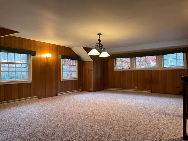 an empty room with fan and windows