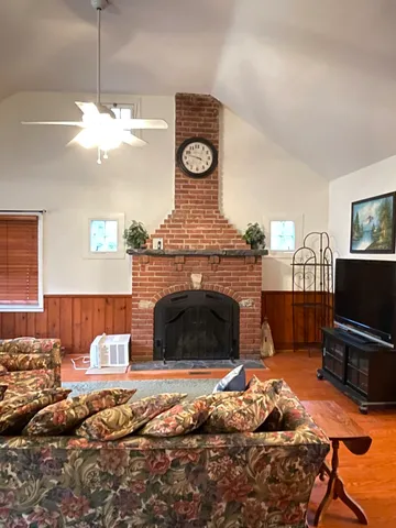 a living room with furniture a flat screen tv and a fireplace
