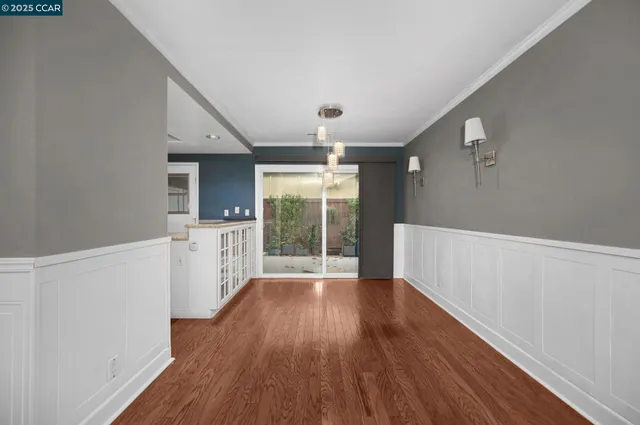 a hallway with wooden floor chandelier and entryway