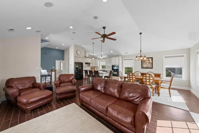 a living room with furniture kitchen view and a chandelier