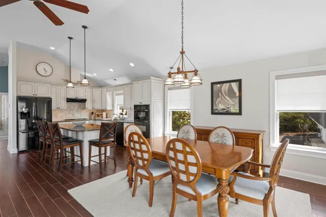 a dining room with furniture a chandelier and wooden floor