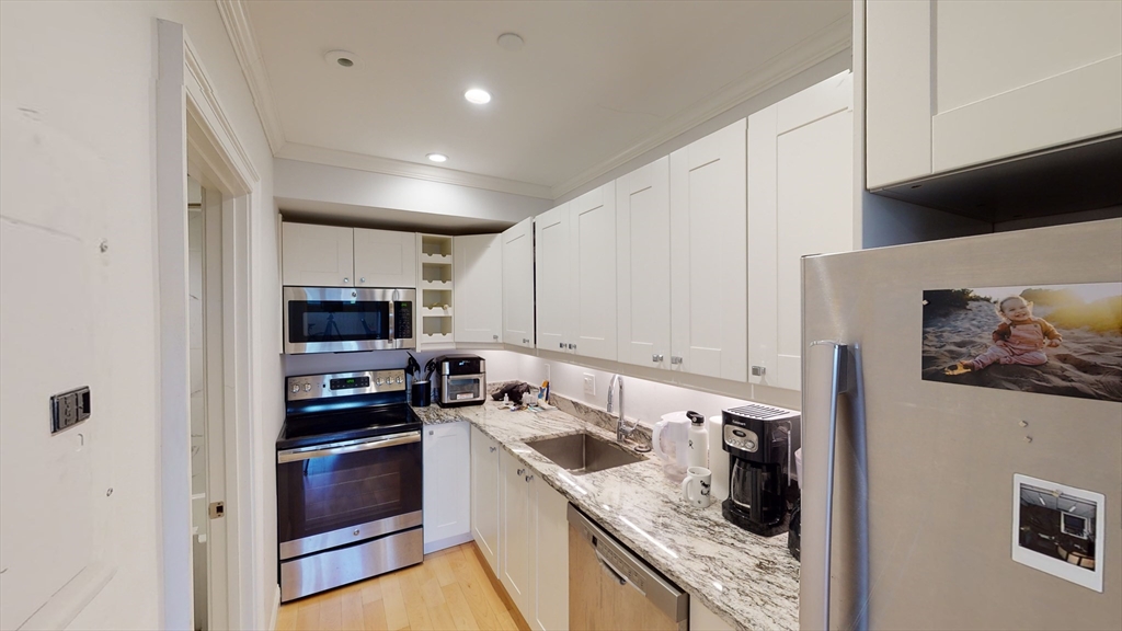 296 Beacon Street, Unit 2 Boston, MA 02116 - Photo 5 of 13 a kitchen with a sink a stove and cabinets