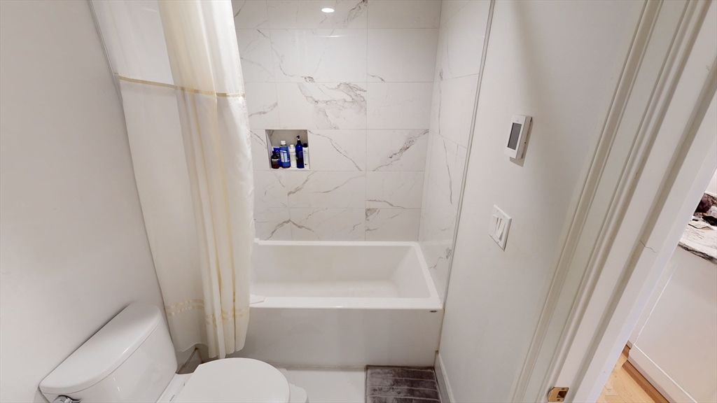 296 Beacon Street, Unit 2 Boston, MA 02116 - Photo 7 of 13 a bathroom with a bathtub and toilet