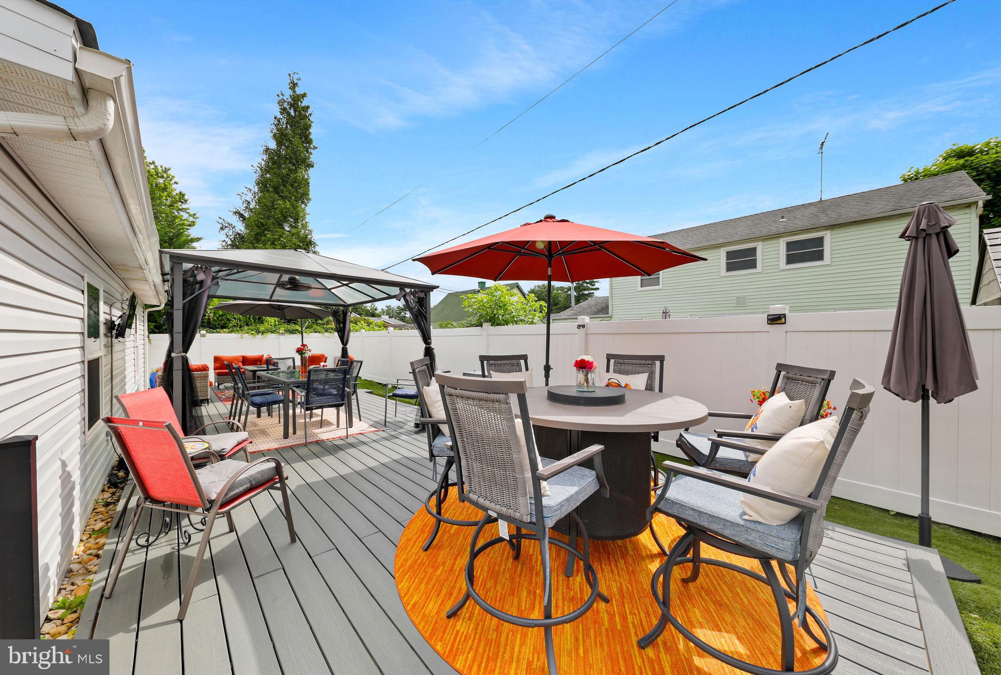 20 Pebble Lane Willingboro, NJ 08046 - Photo 34 of 38 a view of a patio with table and chairs under an umbrella with wooden floor