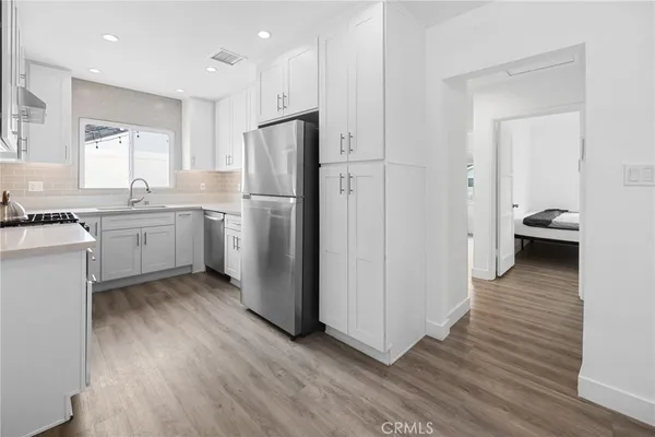 a kitchen with a refrigerator a sink and wooden cabinets