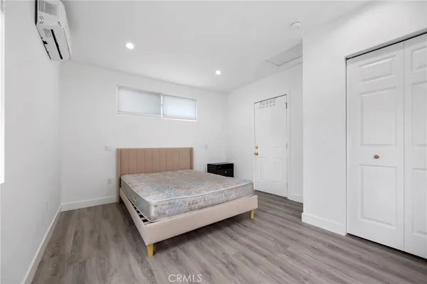 a spacious bedroom with a bed and a wooden floor