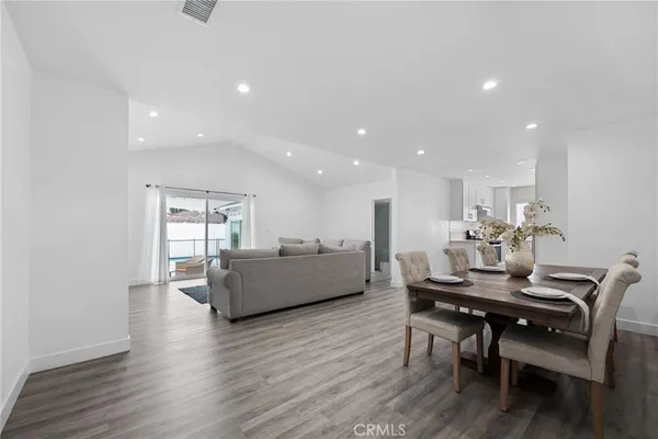 a living room with furniture a wooden floor and a piano